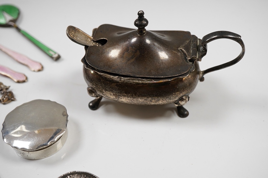 Assorted silverware including a late Victorian mother of pearl handled butter knife, a George V pill box, an Edwardian mustard pot with plated spoon, two enamelled golf related spoons, a rifle shooting related spoon, six